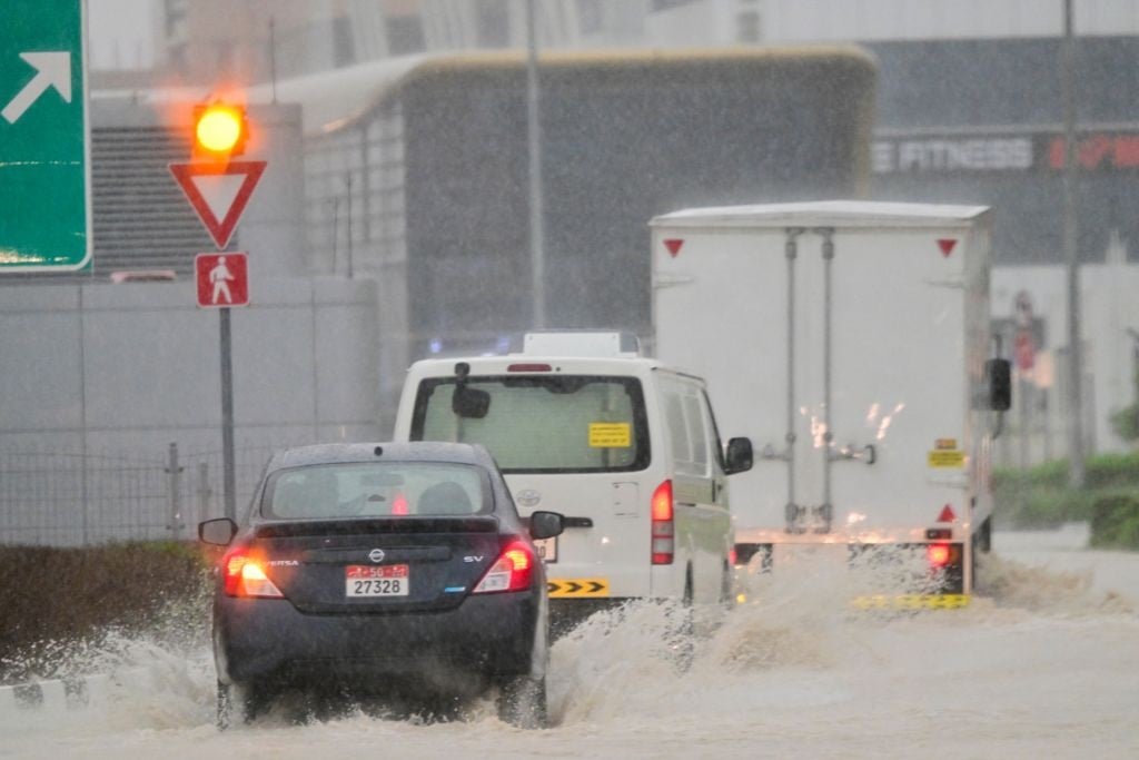 در 16 آوریل 2024، طی باران سیل آسا در امیرنشین خلیج دبی، وسایل نقلیه در جاده‌ای سیل‌زده می‌روند. (Giuseppe Cacce/AFP)
