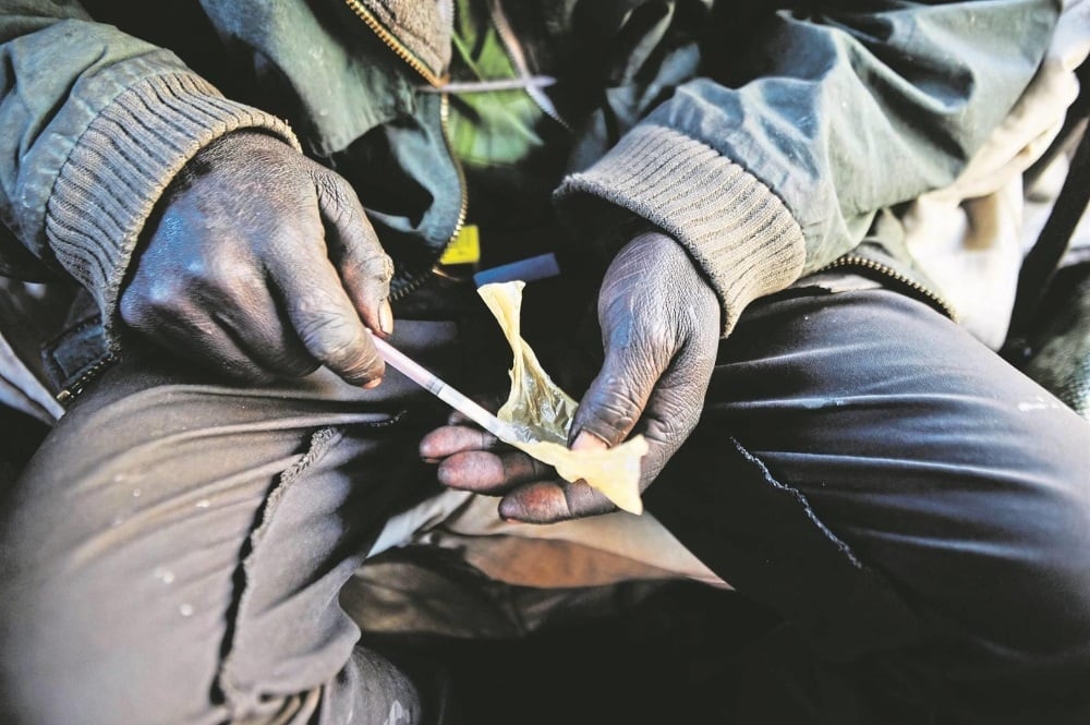 A man prepares an injection of nyaope under the Joe Slovo bridge. The drug contains a mixture of heroin, cannabis and antiretrovirals. (Rosetta Msimango/City Press)