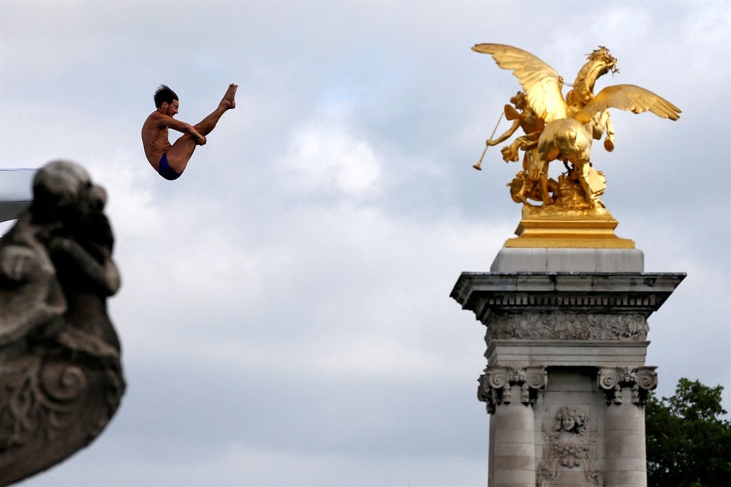 A participant dives from the Pont Alexandre III br