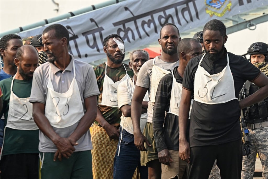 Accused Somali pirates wait to be transferred to police custody at the Indian naval dockyard in Mumbai on 23 March, 2024. India brought 35 accused Somali pirates to Mumbai, days after they were apprehended when naval commandos recaptured a hijacked bulk carrier and rescued several hostages. (Indranil Mukherjee/AFP)