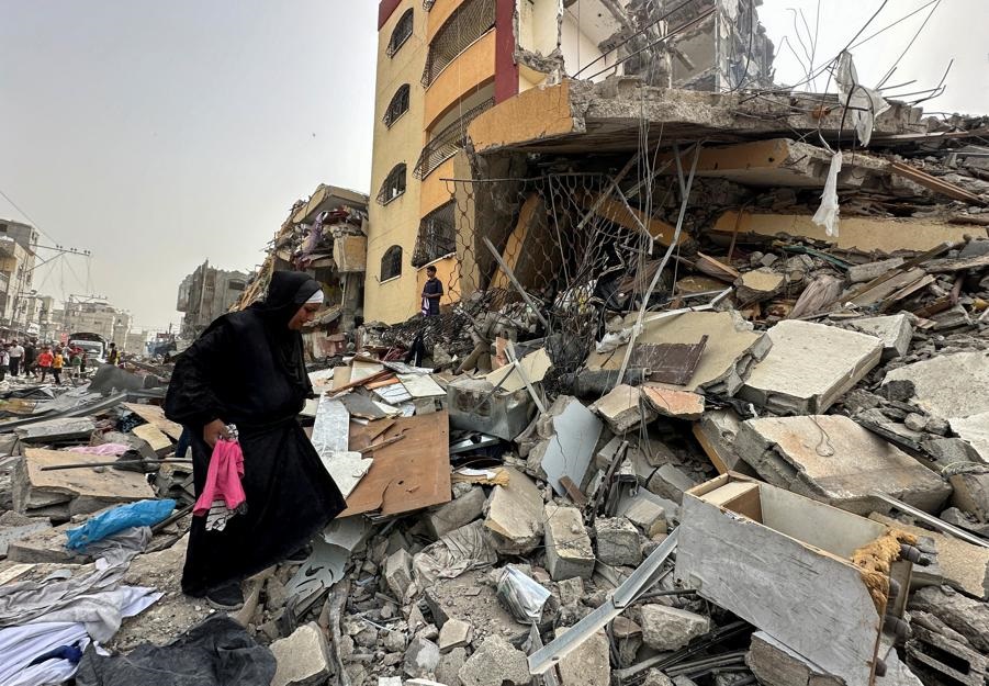 A Palestinian woman searches for her belongings after her apartment was destroyed in an Israeli raid, amid the ongoing conflict between Israel and the Palestinian Islamist group Hamas, in Nuseirat, in the central Gaza Strip, April 18, 2024. Photo: Reuters