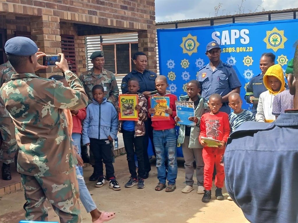 The SANDF and SAPS members handing over books to t