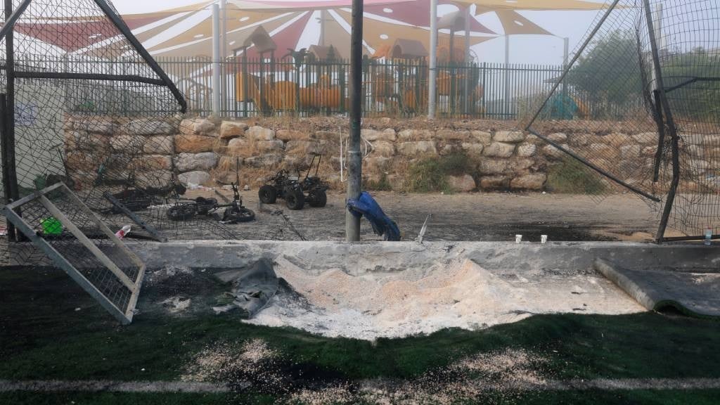 A damaged gate and debris are seen at a football p