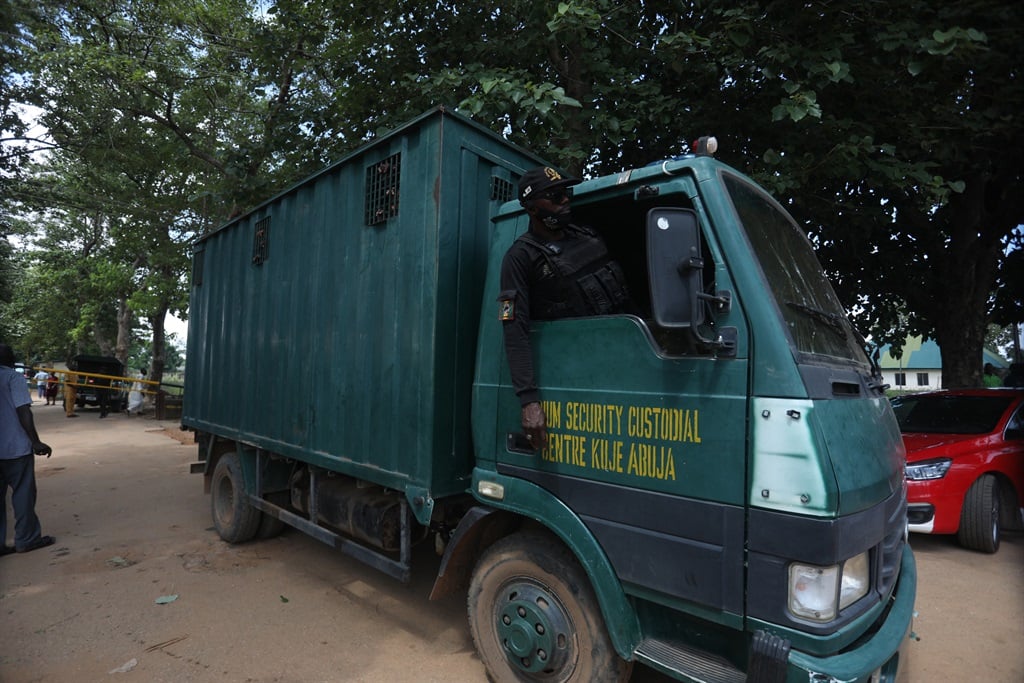 Un oficial se asoma desde un vehículo de la prisión de Nigeria que transporta a los reclusos que escaparon en Abuja, Nigeria, el 6 de julio de 2022. (Kola Sulaimon / AFP)