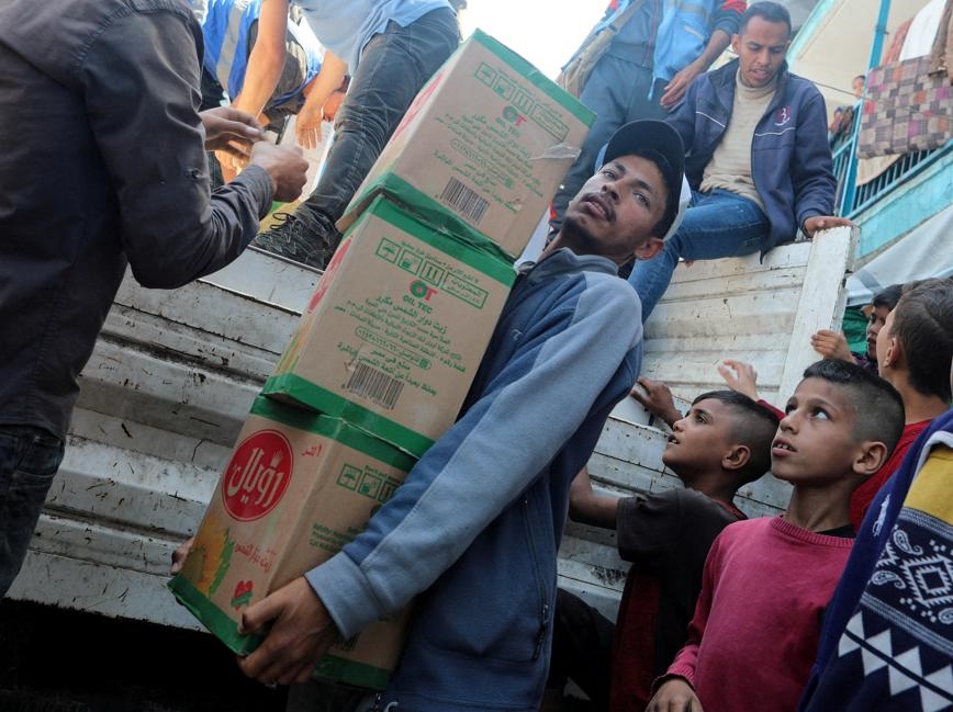 Palestinians distribute aid amid the ongoing conflict between Israel and Hamas, at a shelter center in Deir Al-Balah, in the central Gaza Strip April 7, 2024. Photo by REUTERS