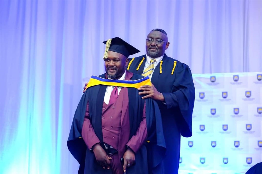 Simbongile Qabaka at his graduation ceremony with Actor Katurura, the University of Fort Hare's acting deputy registrar for academic administration (Supplied)