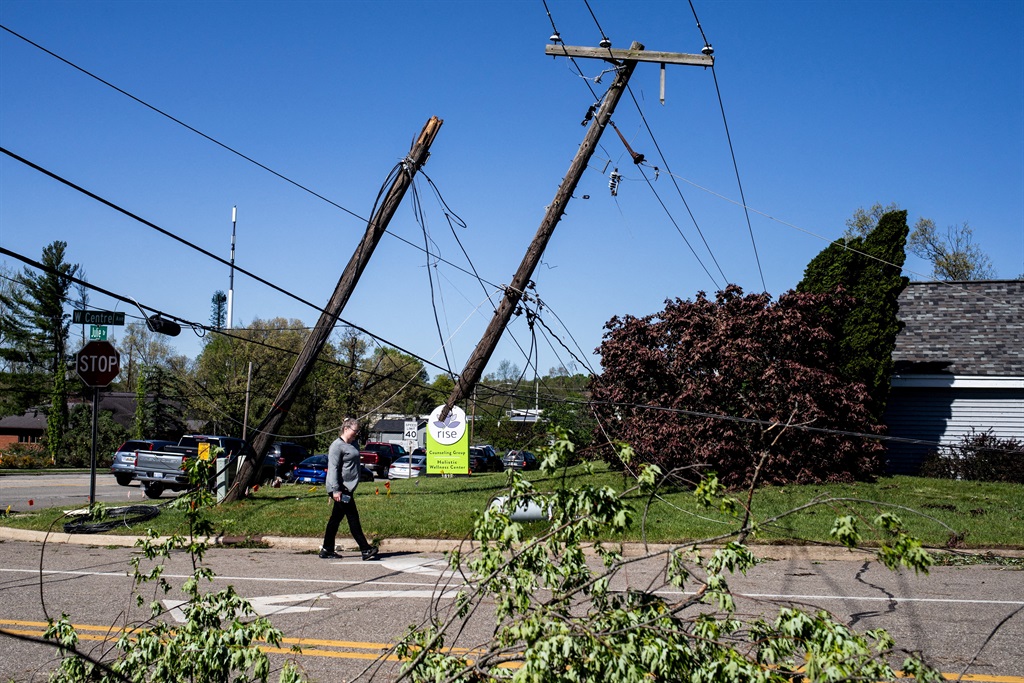 A resident walks past downed electrical lines afte