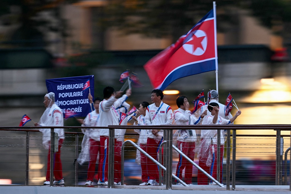 Athletes from North Korea's delegation sail in a b