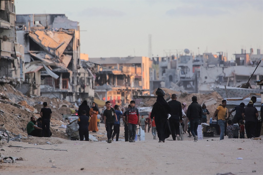Displaced Palestinians walk near buildings destroyed in Israeli bombardment in Khan Yunis in the southern Gaza Strip on 15 May 2024, amid the ongoing conflict between Israel and the Hamas militant group. (AFP)