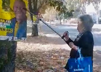 KYK | Vrou vas wat glo ANC-plakkate met kierie verwyder