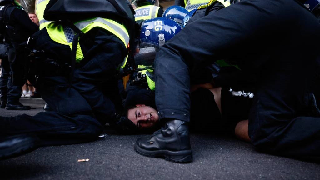 Police officers detain a protestor during the 'Eno