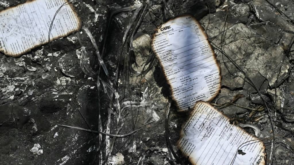 Burnt documents lie at the accident site a day after a fire blazed through a children's hospital in New Delhi. (Arun Sankar/AFP)