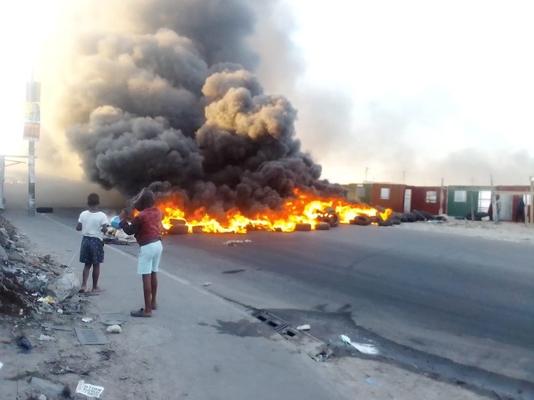 Protesters blocked busy roads in Philippi, Cape Town with burning tyres. (Sandiso Phaliso/GroundUp)