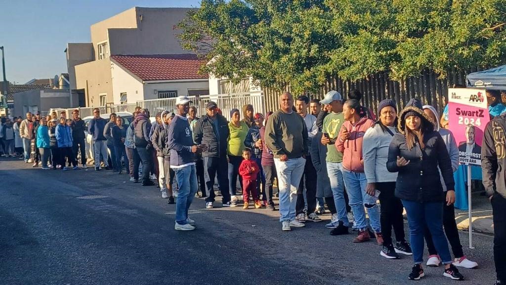 Long queue of people on sidewalk waiting to vote