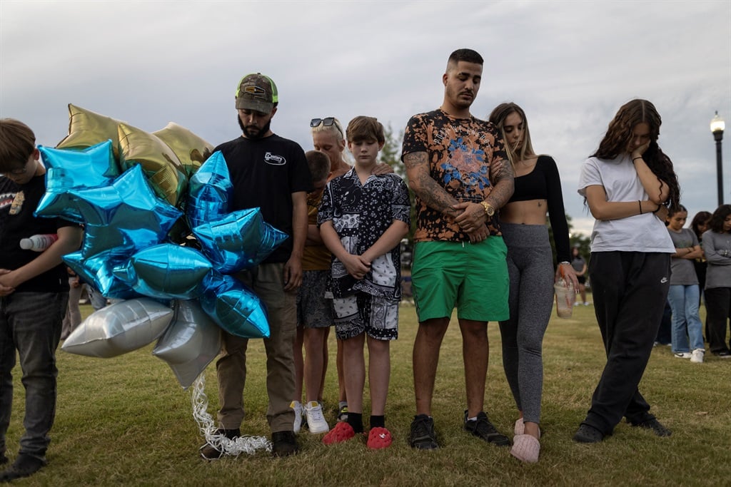 A family prays during a vigil for the victims of t