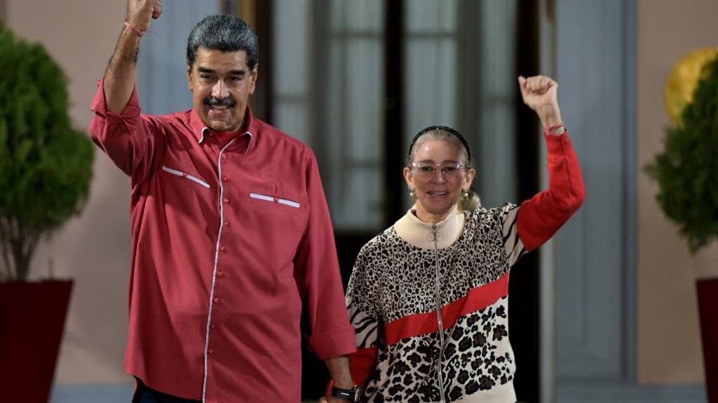 Venezuelan President Nicolas Maduro (L) and his wife Cilia Flores gesture outside Miraflores presidential palace, during a rally in support of the presidential election results in Caracas. (Yuri Cortez/AFP)