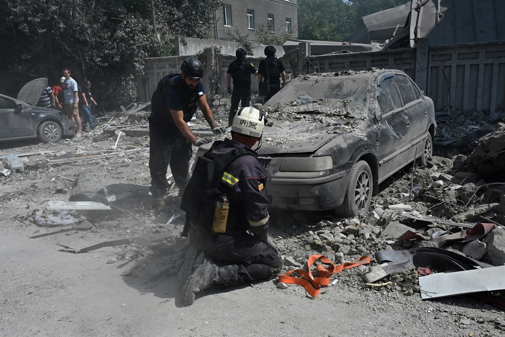 Ukrainian firefighters examine damaged cars at the site of a missile strike in central Kharkiv on 6 August 2024, amid the Russian invasion of Ukraine. (Sergey Bobok/ AFP)