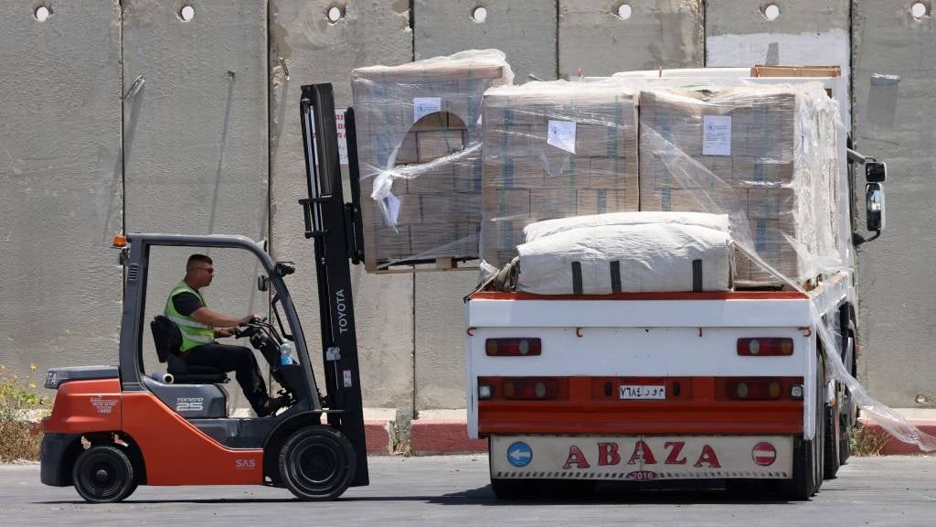 A worker loads humanitarian aid for the Gaza Strip