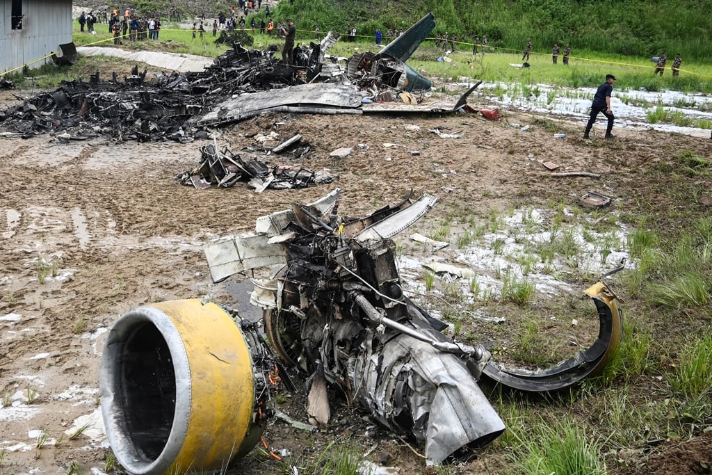 Officials examine the site after a Saurya Airlines' plane crashed during takeoff at the Tribhuvan International Airport in Kathmandu on 24 July 2024. (Prakash Mathema/AFP)