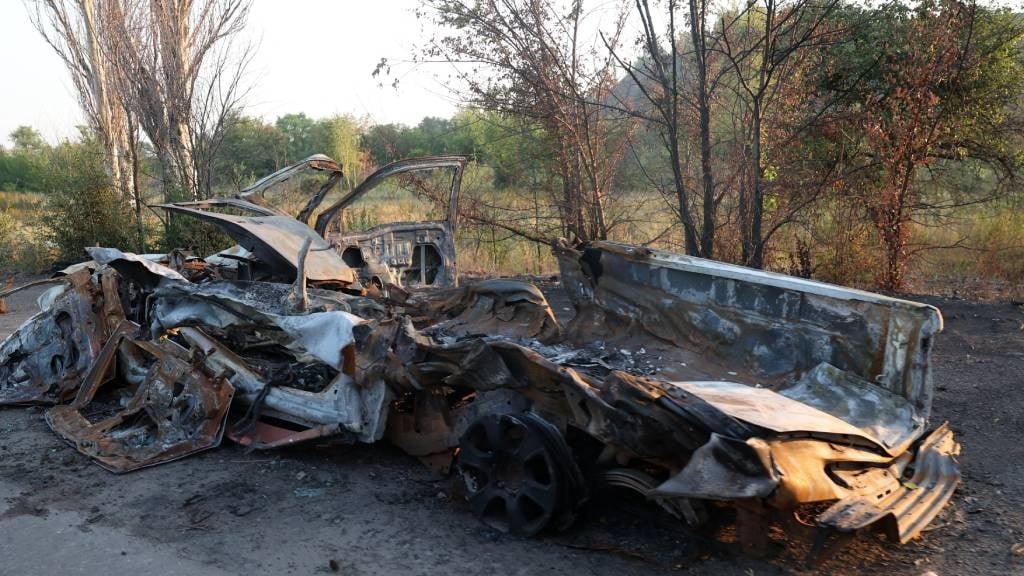 This photograph shows a burnt car in the town of T