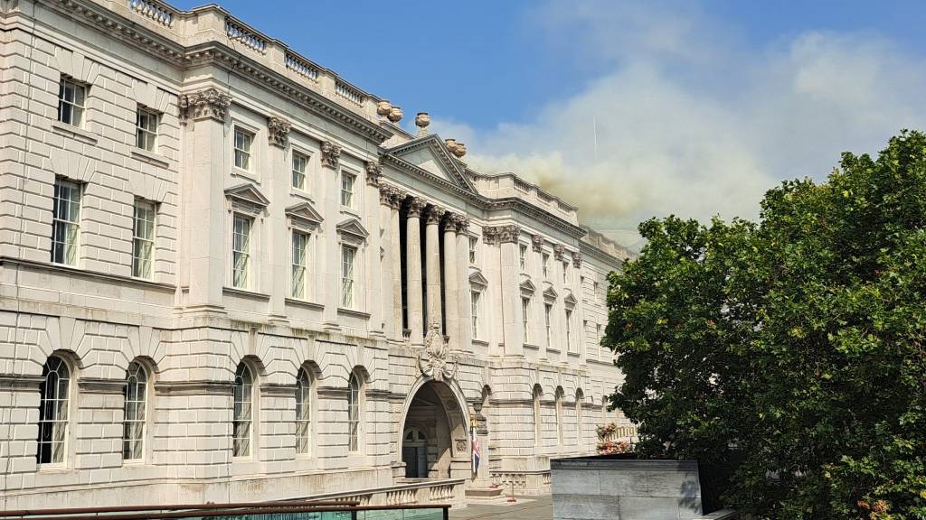 Smoke is seen rising into the sky from a fire located in the roof of Somerset House beside the River Thames in London. (James Rybacki/AFP)