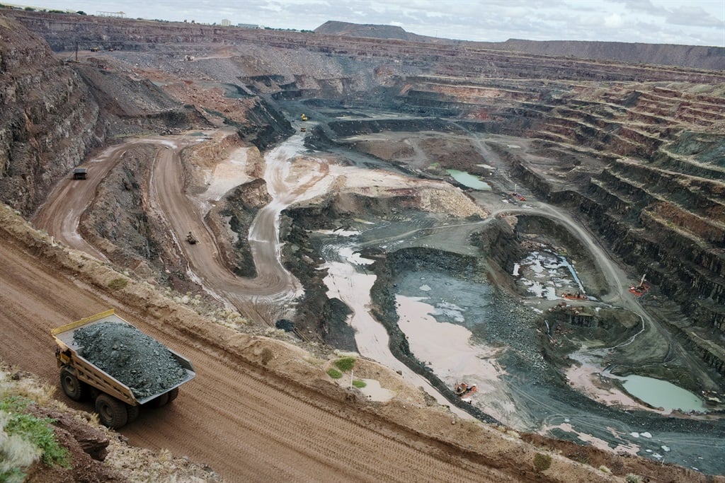 A huge mining truck hauls a big load of ore from t