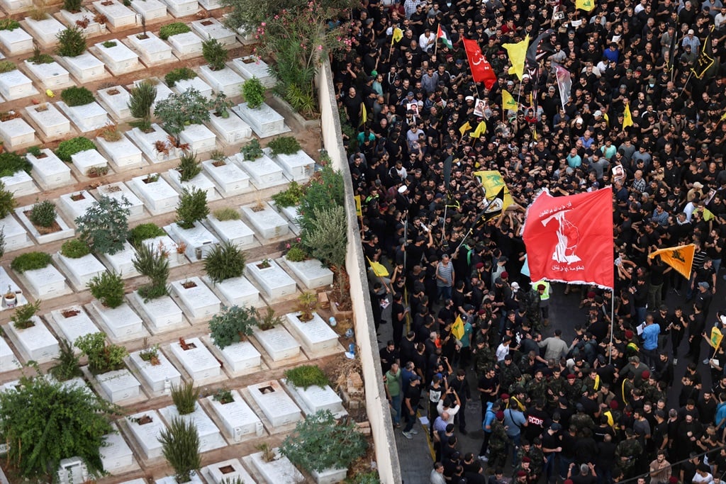 A crowd accompanying the casket of slain top Hezbollah commander Fuad Shukr to a cemetery in Beirut on 1 August 2024. (Ibrahim Amro/AFP)