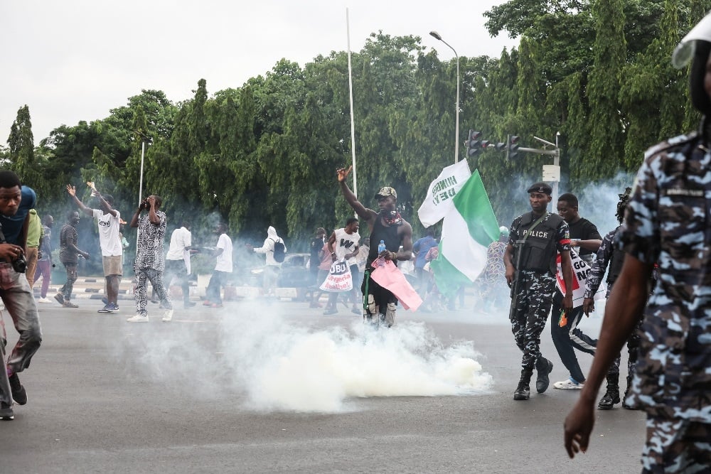 Demonstrators react as Nigerian police fire tear gas canisters during the End Bad Governance protest in Abuja on 1 August 2024. (Kola Sulaimon/AFP)