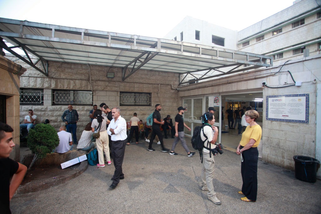 People anxiously gathered outside hospital buildin