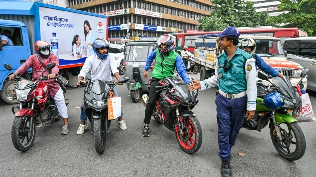 A police personnel controls traffic at a road inte