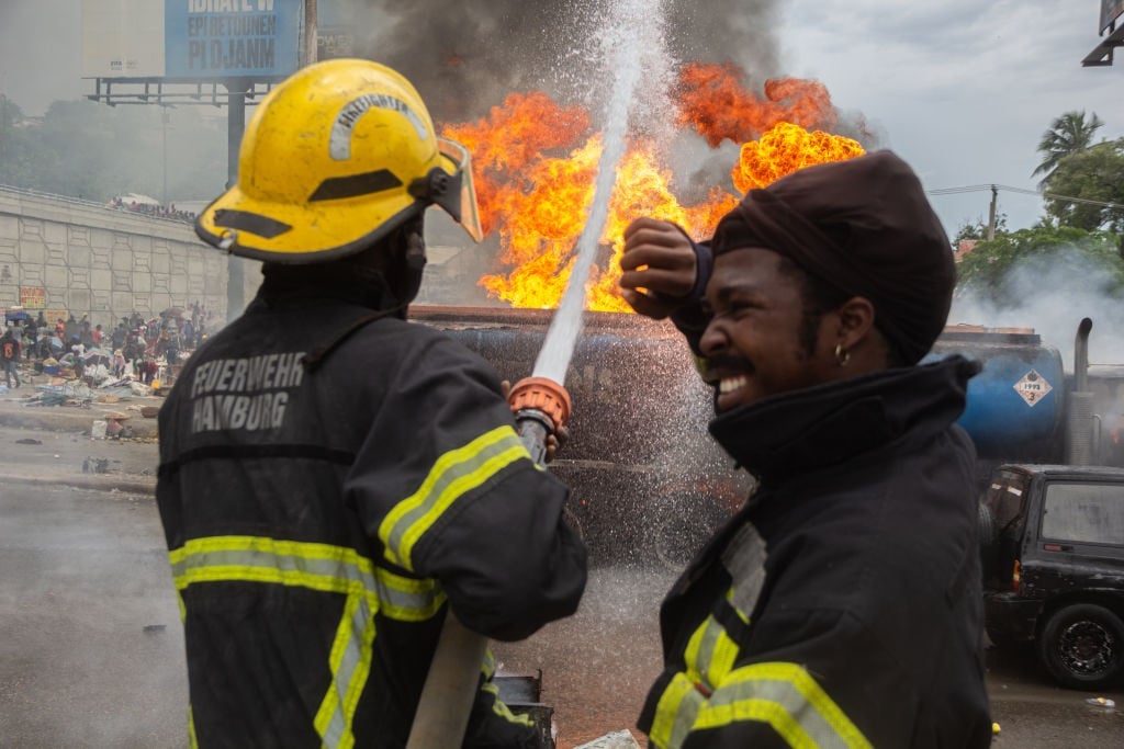 Firefighters extinguish a fire after a tanker carrying diesel exploded when it was hit by projectiles fired by armed men trying to apprehend the truck in Port-au-Prince, Haiti on 4 June 2024. (Guerinault Louis/Anadolu via Getty Images)