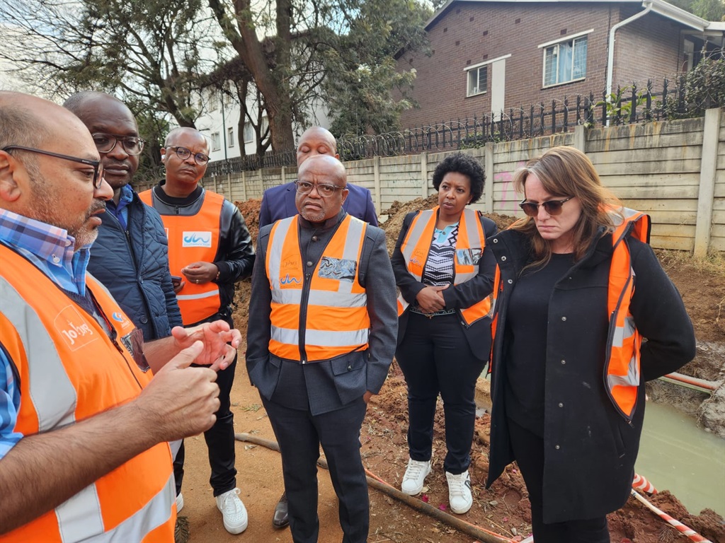 Joburg Mayor Dada Morero (M) looks on as members of Johannesburg Water and ward councillor Nicole Van Dyk (R) show him a water pipe which has burst over 20 times this year on Republic Road. (Alex Patrick/News24)