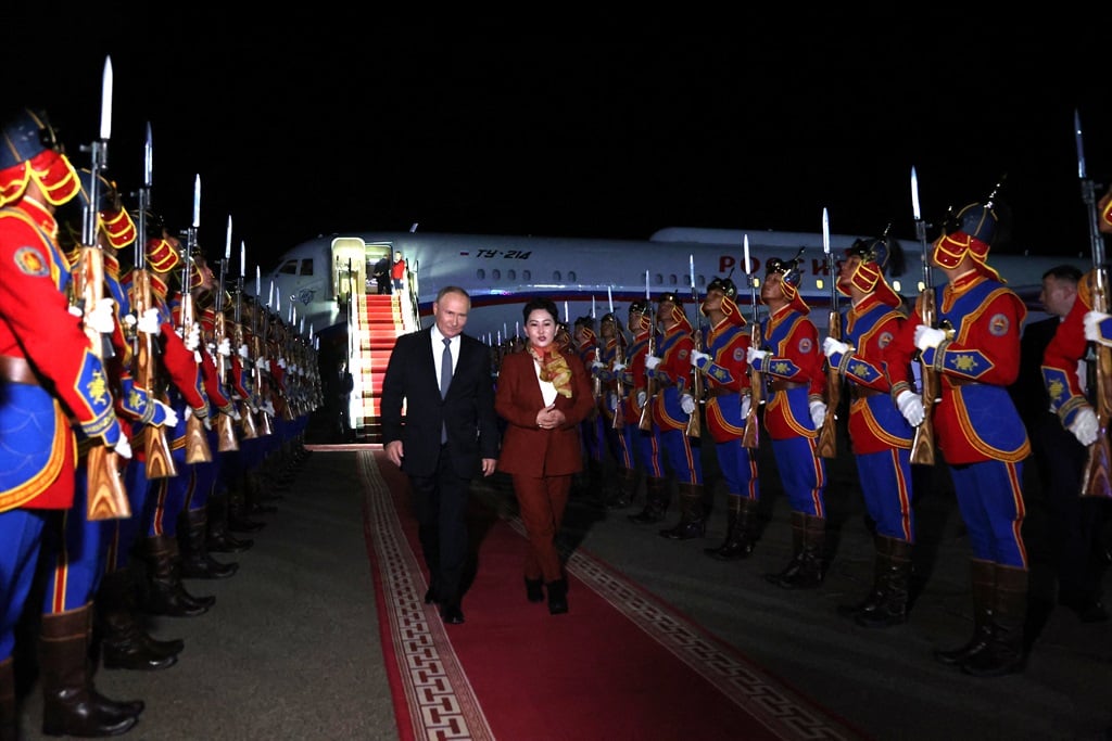 Russia's President Vladimir Putin, accompanied by Battsetseg Batmunkh, Mongolia's Minister of Foreign Affairs, walks past honour guards upon arrival at the airport in Ulaanbaatar on 2 September 2024. (Natalia Gubernatorova / POOL / AFP)