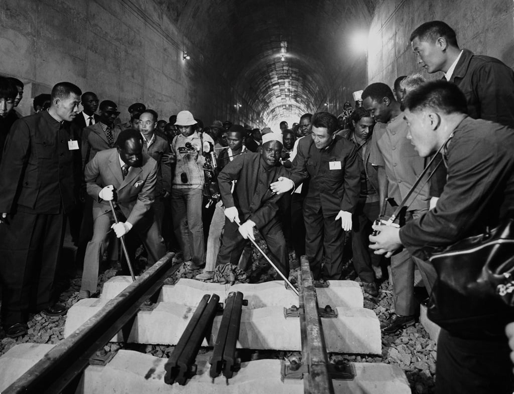 The border-crossing track section is levered into place by Zambian and Tanzanian officials helped by Chinese engineers during construction of the Tazara Railway, in Tunduma, Tanzania, in September 1973. Also known as the called the Great Uhuru Railway, the single-track railway connects the port of Dar es Salaam, Tanzania, with the town of Kapiri Mposhi, Zambia. (Mohamed Amin/Camerapix/Keystone/Hulton Archive/Getty Images)