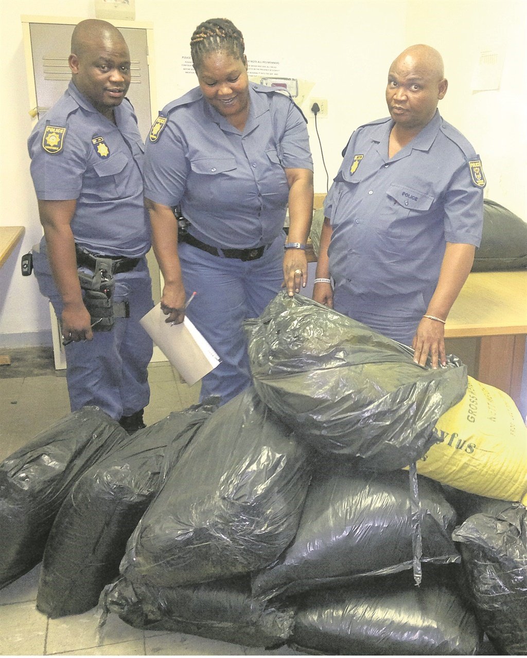 Constables Lesego Atoro and Ngcelo Nele and Warrant Officer Nathan Romein with the bags they confiscated. Photo supplied by SAPS
