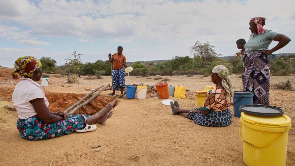 Women make use of their turn to draw water at a village well, which has very limited reserves of water left to meet their household water needs for drinking, cooking and sanitation. (Jekesai Njikizana/AFP)
