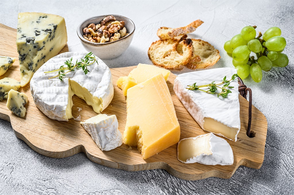Assorted cheeses on a wooden cutting Board. Camemb