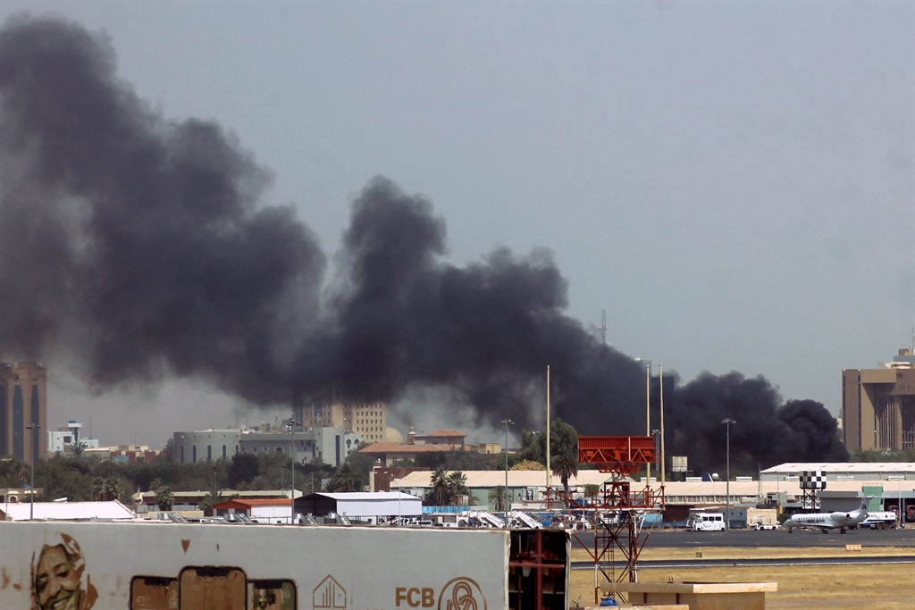 Humo denso brota sobre los edificios en las cercanías del aeropuerto de Jartum el 15 de abril de 2023, en medio de enfrentamientos en la capital sudanesa.  Explosiones sacudieron la capital sudanesa el 15 de abril cuando los paramilitares y el ejército regular intercambiaron ataques entre sí, días después de que el ejército advirtiera que el país estaba en un "peligroso" punto de retorno.