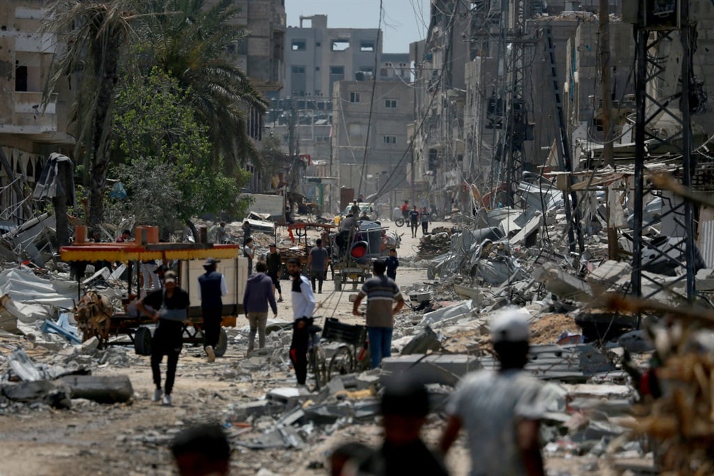 فلسطینی ها در 29 آوریل 2024 در میان آوار ساختمان های ویران شده در نصیرات در مرکز نوار غزه قدم می زنند، در میان درگیری های جاری در خاک فلسطین بین اسرائیل و شبه نظامیان حماس.  (AFP)