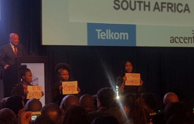 President Jacob Zuma gives his speech at the IEC’s results centre in Pretoria while women protest in front of the stage. (Karabo Ngoepe, News24)