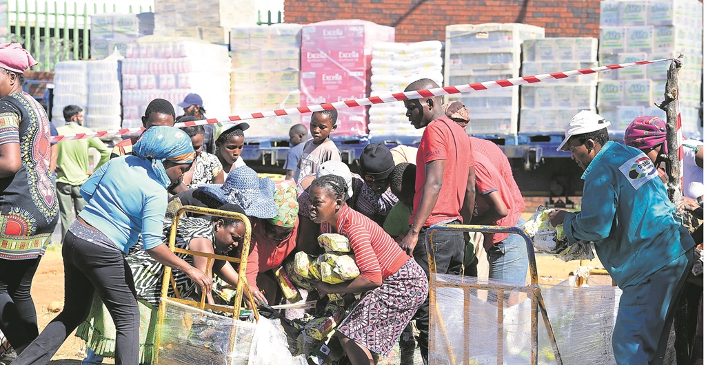 When a cash and carry warehouse In Devland burst into flames, residents started helping themselves to groceries that had been thrown out. 