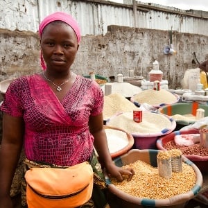 Monrovia, Liberia - February 19, 2012: A woman stands in front of her market stall selling various grains in Monrovia, Liberia.
