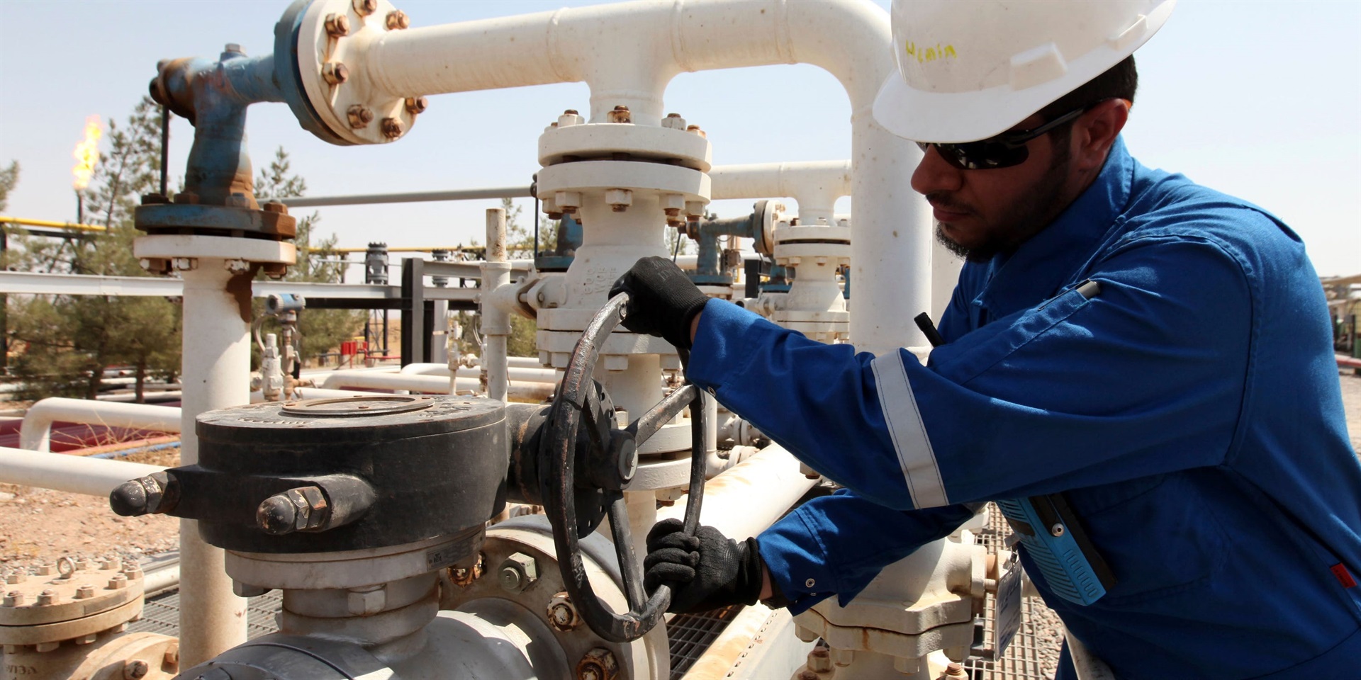 A worker adjusts a valve of an oil pipe. Azad Lash