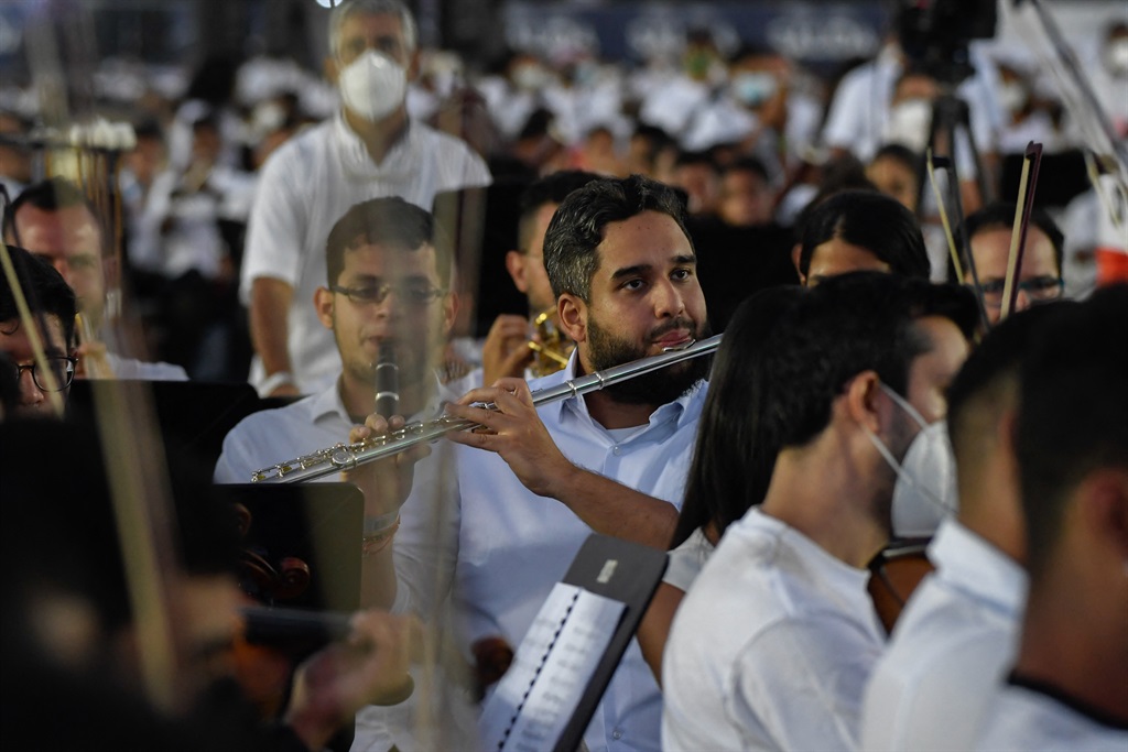 Venezuelan National Assembly deputy, Nicolas Ernesto Maduro Guerra (C), son of President Nicolas Maduro plays his flute during an attempt to enter the Guinness Book of Records for the largest orchestra in the world, with more than 12 000 musicians, at the Military Academy of the Bolivarian Army in Fuerte Tiuna Military Complex, in Caracas. (Federico PARRA / AFP)