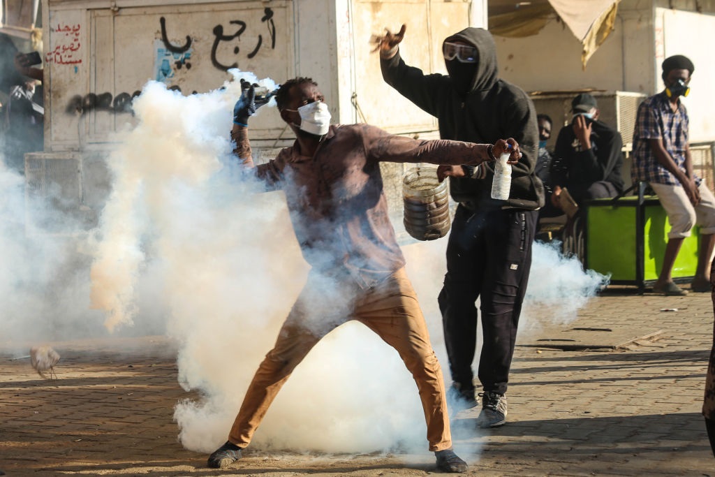 Protesters clash with security forces as they try to march to the Presidential Palace during a demonstration demanding civilian rule in Khartoum. (Photo by Mahmoud Hjaj/Anadolu Agency via Getty Images)