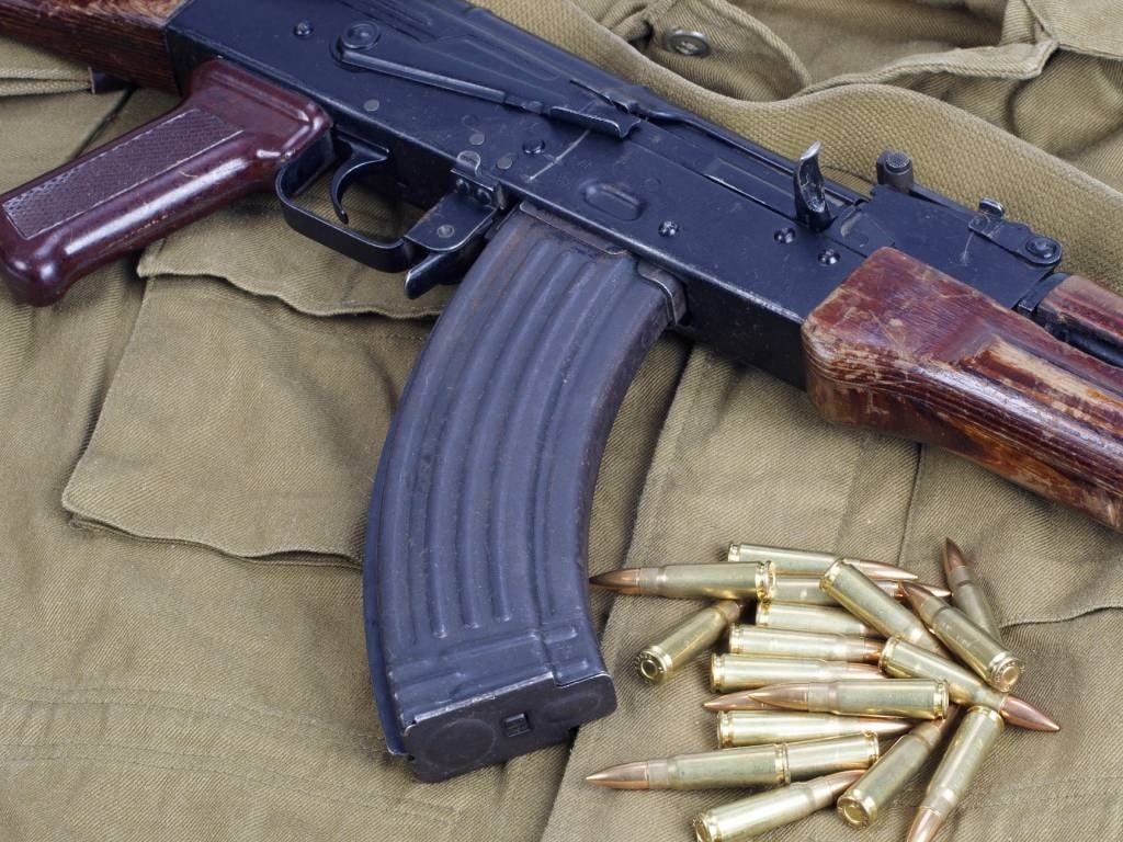 Police arrested a man who they charged with murder and who was in possession of an AK-47.
