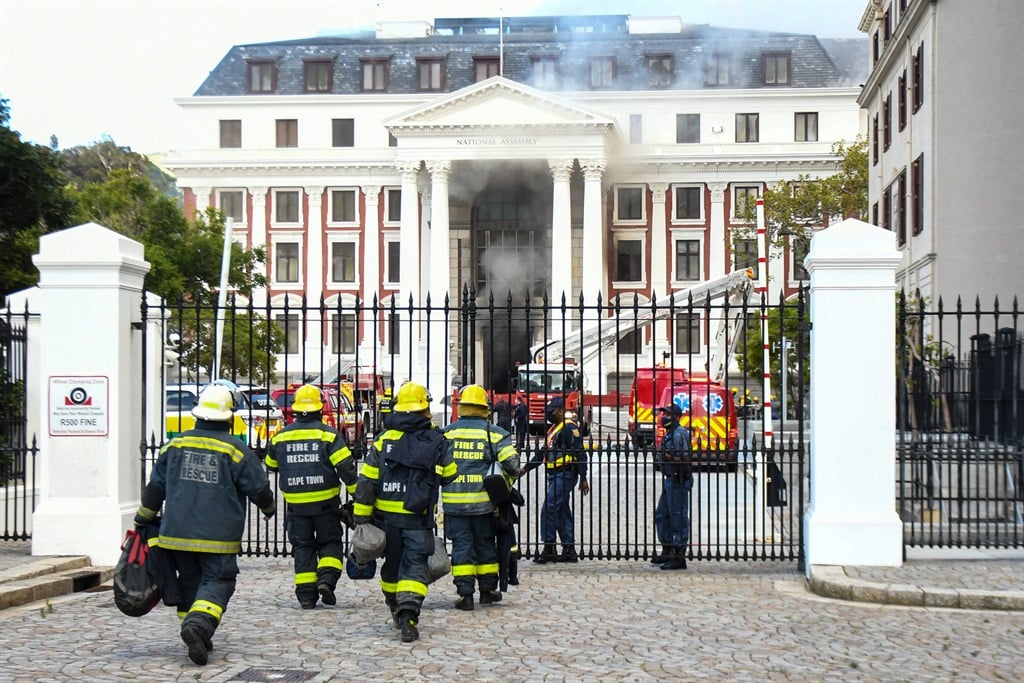 Firefighters race into the Parliament building which was on fire.