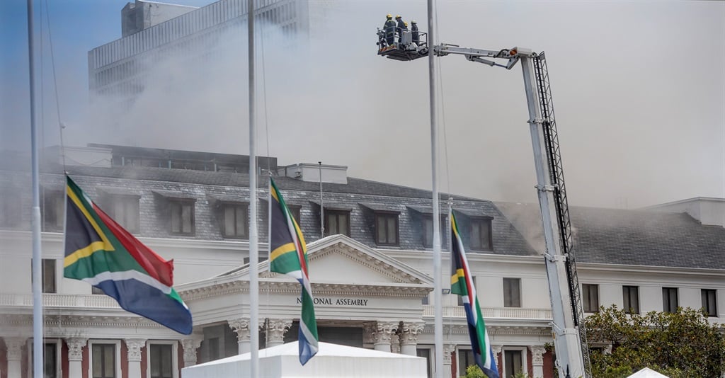 Flags hang half mast in respect for Archbishop Tutu as a fire at  National Assembly in Parliament rages on on January 2 2022 in Cape Town. Photo: Brenton Geach/Gallo Images