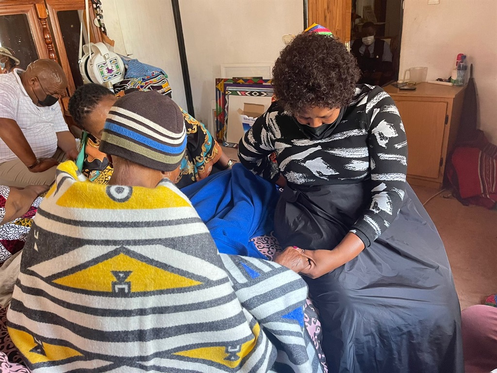 Premier Refilwe Mtsweni-Tsipane praying with Esther Mahlangu at her home.  