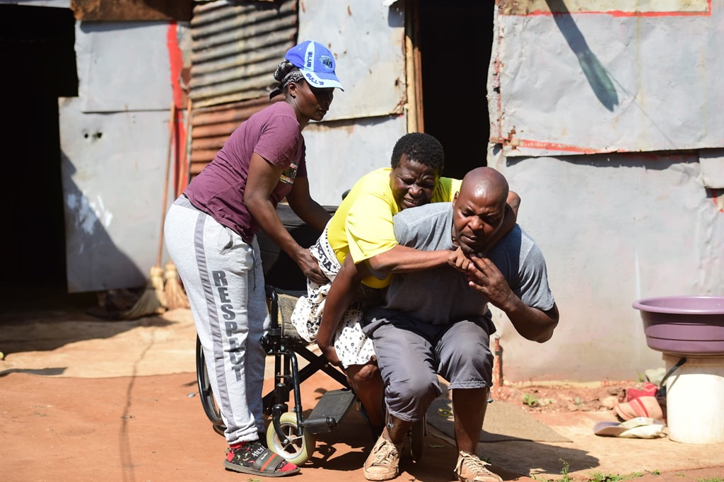 Joshua Baloyi and Noxolo Ludidi help Gloria Ludidi get in and out of her home. Photos by Raymond Morare